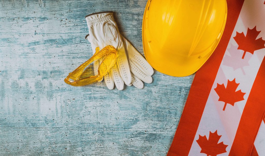 construction hat, gloves, and Canadian flag on a table